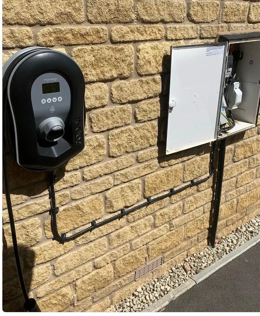 Zappi EV charger and isolator installed on a stone wall with neat conduit runs by SEE Electrical, Worcester